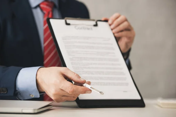 Cropped view of agent holding clipboard with contract lettering and pen — Stock Photo