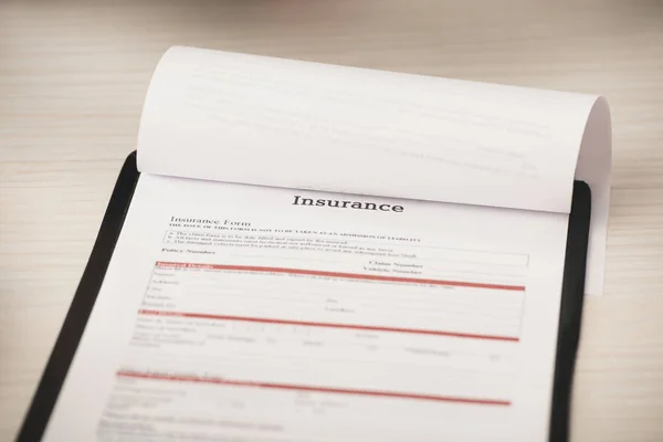 Mise au point sélective du presse-papiers avec lettrage d'assurance du bureau — Photo de stock