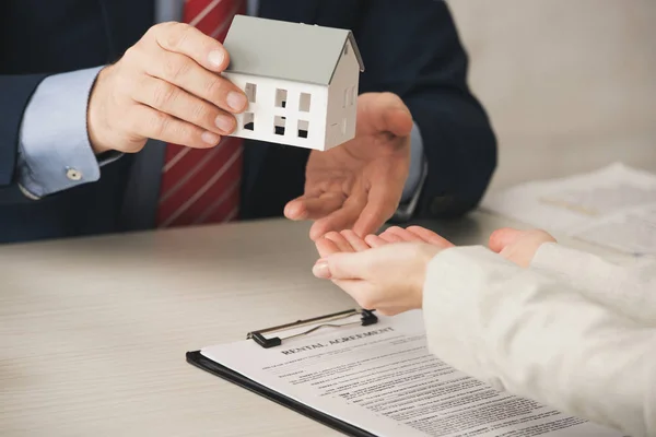 Vue recadrée de l'agent donnant modèle de maison à la femme avec les mains coupées — Photo de stock