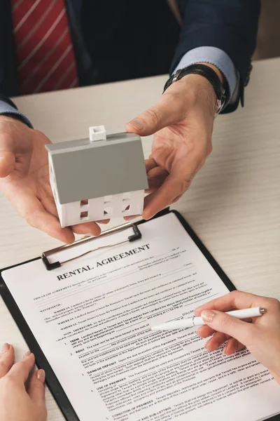 Vue du dessus du modèle de maison de holding agent près de la femme avec stylo à la main et contrat de location — Photo de stock