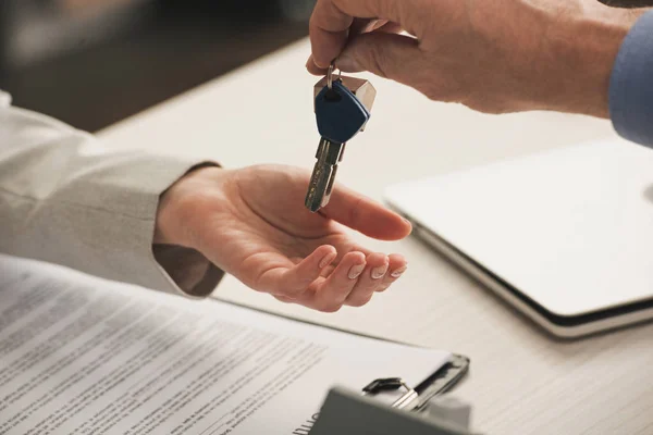 Cropped view of man giving keys to client — Stock Photo