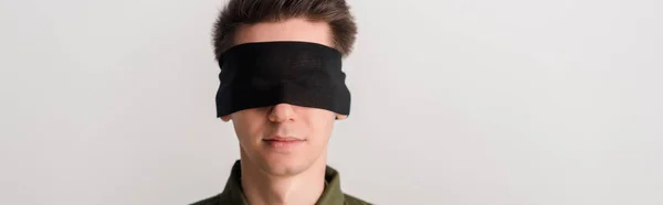 Plano panorámico del hombre con los ojos vendados aislado en blanco, concepto de derechos humanos - foto de stock