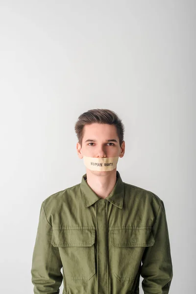 Homme impuissant avec scotch ruban sur la bouche avec des droits de l'homme lettrage isolé sur blanc — Photo de stock