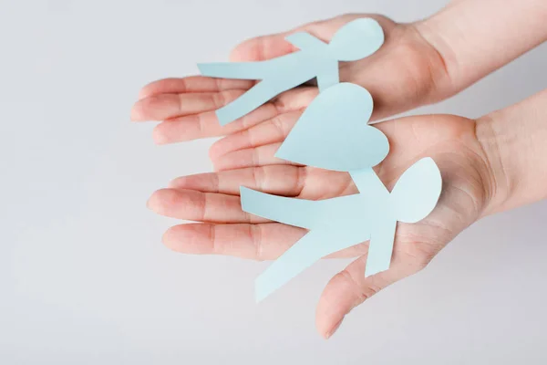 Cropped view of woman holding figures of people cut from paper with heart, human rights concept — Stock Photo