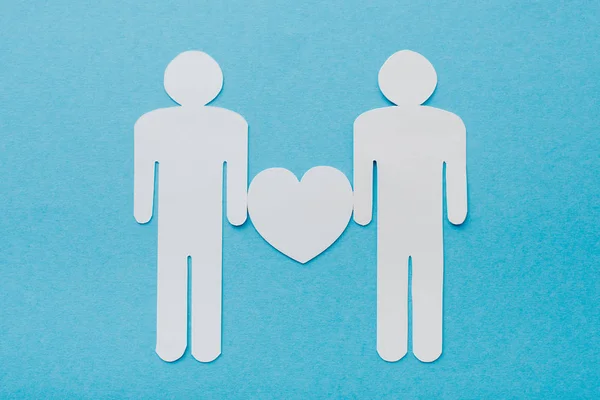 Вид зверху на паперові вирізані фігури гомосексуальної пари ізольовані на синьому, концепція прав людини — стокове фото