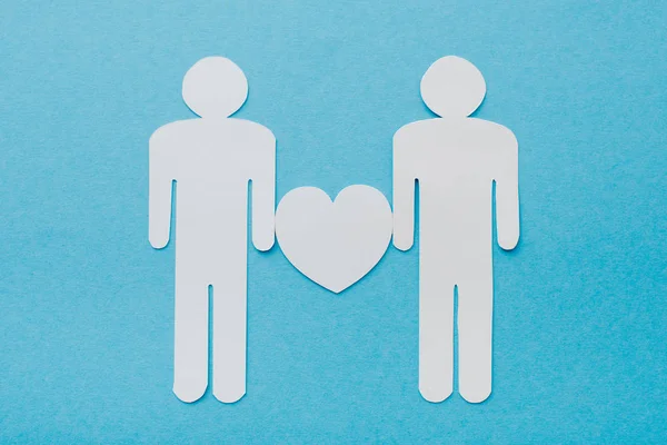 Top view of paper cut figures of homosexual couple isolated on blue, human rights concept — Stock Photo