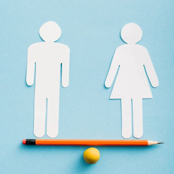 Paper cut figures of couple as gender equality on pencil with small ball isolated on blue, sexual equality concept — Stock Photo