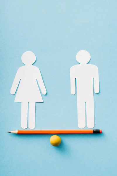 Papierfiguren von Paaren als Gleichberechtigung der Geschlechter auf Bleistift mit Ball isoliert auf blau, Konzept der Gleichberechtigung der Geschlechter — Stockfoto