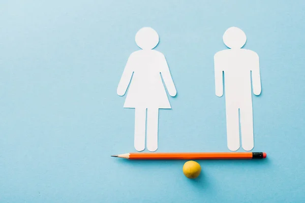 Bola pequena e lápis com corte de papel de casal isolado em azul, conceito de igualdade sexual — Fotografia de Stock