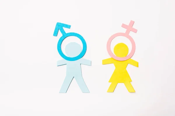 Top view of blue and yellow paper cut people near gender signs isolated on white, sexual equality concept — Stock Photo