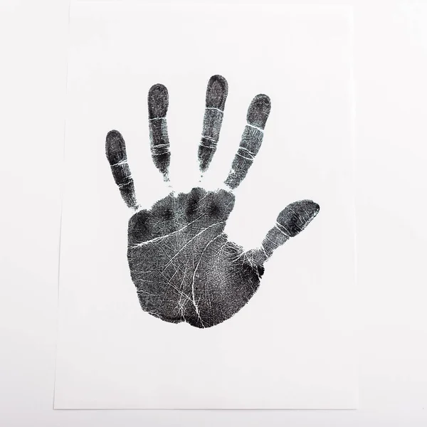 Draufsicht auf schwarzen Handabdruck auf Papier isoliert auf weißem, Menschenrechtskonzept — Stockfoto