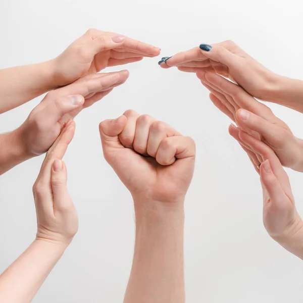 Visión recortada de las mujeres protegiendo la mano del hombre con el puño cerrado aislado en el concepto blanco de derechos humanos - foto de stock