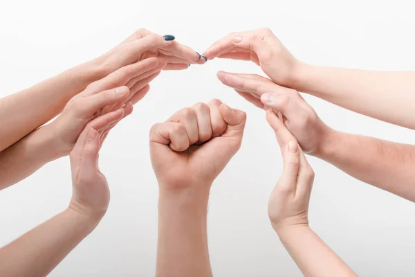 Vista ritagliata delle donne che proteggono la mano dell'uomo con pugno stretto durante lo sciopero isolato sul bianco, concetto di diritti umani — Foto stock