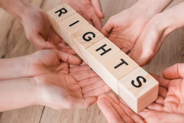 Cropped view of group holding wooden cubes with rights lettering — Stock Photo