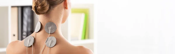 Rückansicht einer Frau mit Elektrostimulationselektroden am Hals, Panoramaaufnahme — Stockfoto