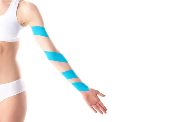 Vista cortada de mulher jovem com fitas de cinesiologia na mão isolada em branco — Fotografia de Stock