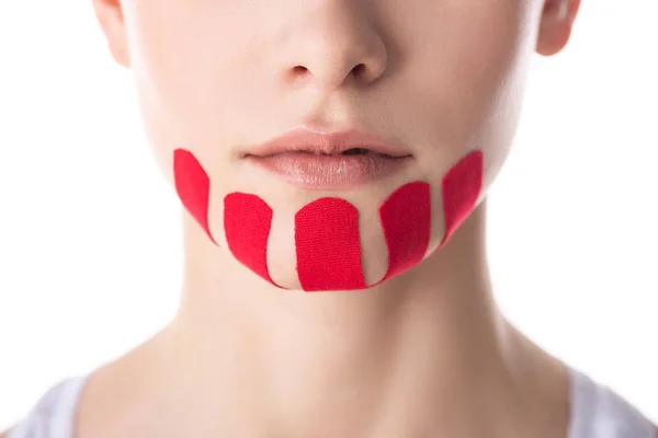 Cropped view of woman with kinesiology tapes on chin isolated on white — Stock Photo