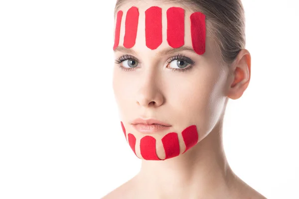 Beautiful girl with kinesiology tapes on chin and forehead looking at camera isolated on white — Stock Photo