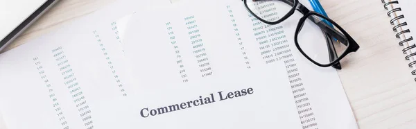 Panoramic shot of document with commercial lease lettering near glasses on desk — Stock Photo