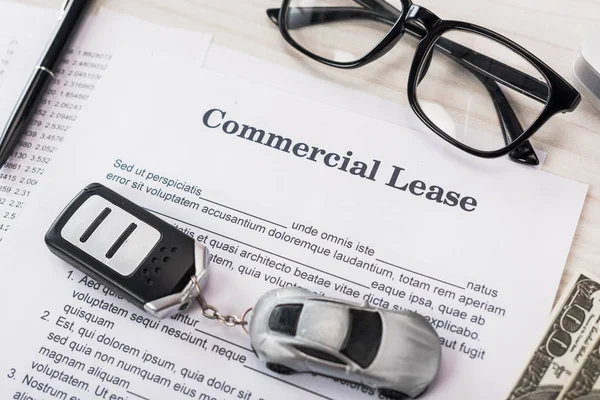 Top view of document with commercial lease lettering near toy car, money and glasses — Stock Photo