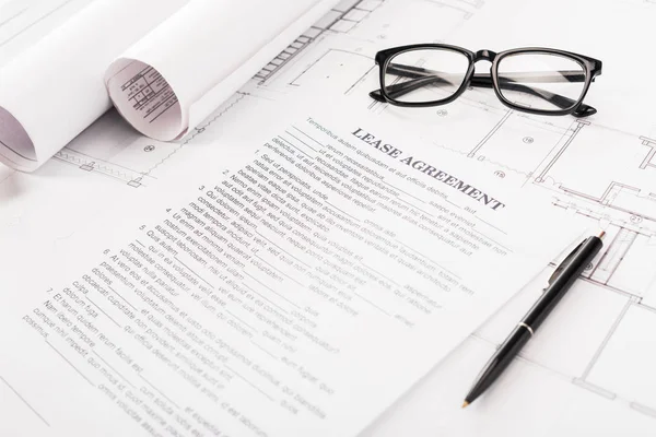 Documento com contrato de locação lettering perto de óculos, plantas e caneta na mesa — Fotografia de Stock