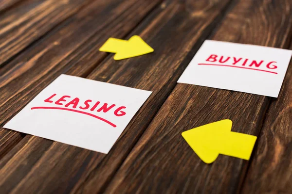 Messa a fuoco selettiva di carte con scrittura di acquisto e leasing su superficie di legno — Foto stock