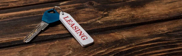 Colpo panoramico di chiave con lettering leasing su superficie in legno — Foto stock