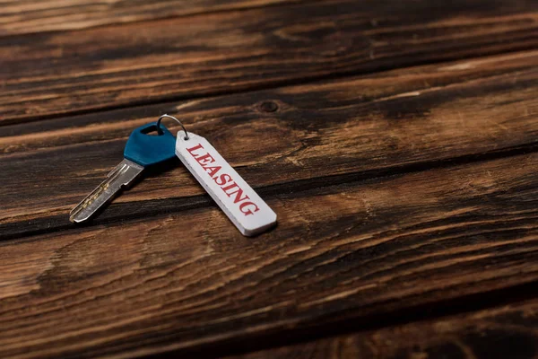 Key with leasing lettering on wooden surface — Stock Photo