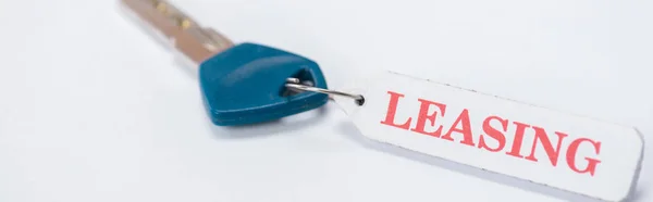 Panoramic shot of key with leasing lettering on white — Stock Photo