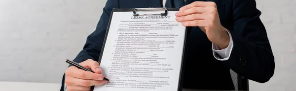 Panoramic shot of realtor holding clipboard with lease agreement lettering on white — Stock Photo