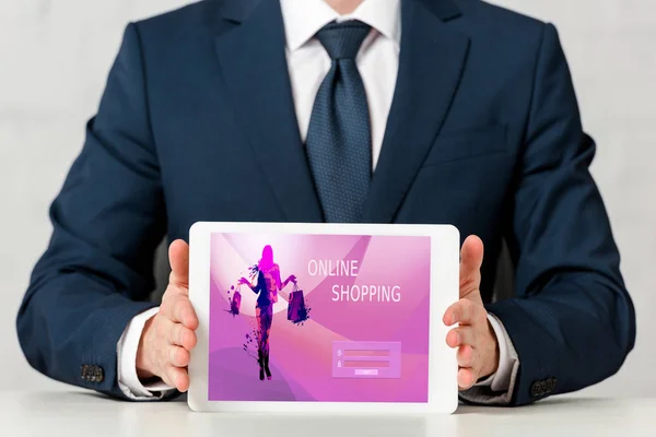 Обрезанный взгляд бизнесмена в костюме проведение цифровой планшет с интернет-покупки на экране на белом — стоковое фото