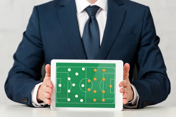 Recortado vista de hombre de negocios celebración de tableta digital con juego en línea en la pantalla en blanco — Stock Photo