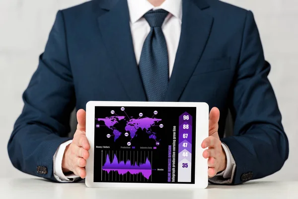 Visão recortada do empresário segurando tablet digital com mapa do mundo, gráficos e gráficos na tela em branco — Fotografia de Stock