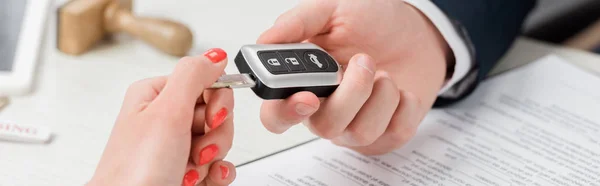 Panoramic shot of realtor giving key to woman, leasing concept — Stock Photo