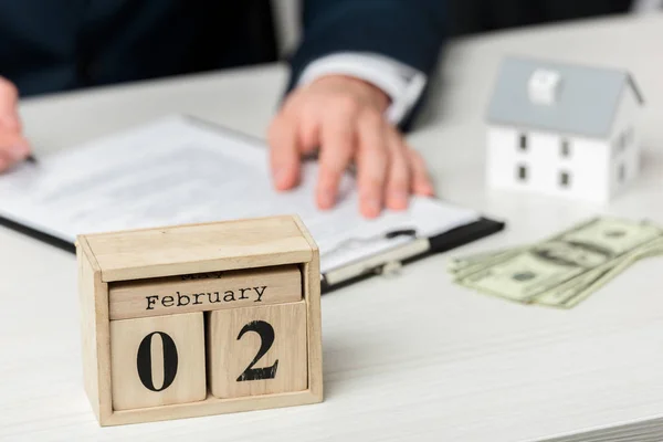 Selective focus of wooden calendar with february lettering near realtor — Stock Photo