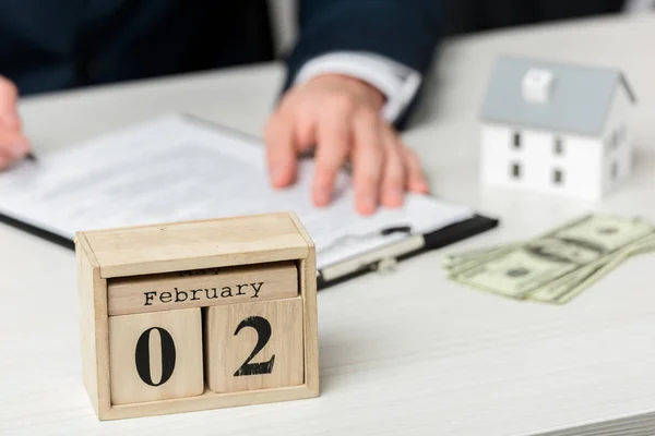 Foyer sélectif du calendrier en bois avec lettrage février près de l'agent immobilier — Photo de stock