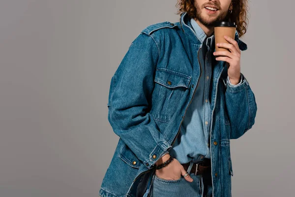 Vue recadrée de l'homme souriant veste en denim tenant tasse en papier isolé sur gris — Photo de stock