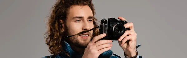 Plano panorámico del hombre sonriente tomando foto aislado en gris - foto de stock