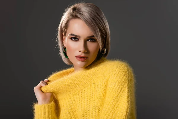 Attrayant femme touchant robe jaune et regardant caméra isolé sur gris — Photo de stock