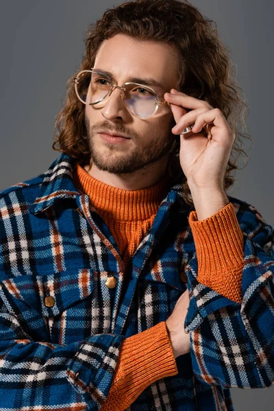 Hombre guapo en camisa y gafas mirando hacia otro lado aislado en gris - foto de stock