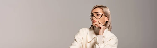 Panoramic shot of attractive woman in white coat looking away isolated on grey — Stock Photo