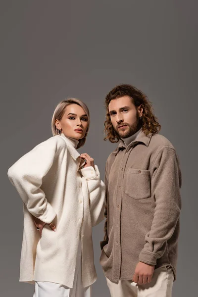 Woman in white coat and man in shirt looking at camera isolated on grey — Stock Photo