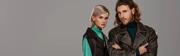 Panoramic shot of woman in vest and man in leather jacket looking at camera isolated on grey — Stock Photo