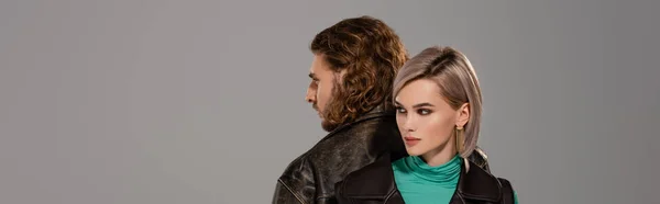 Panoramic shot of attractive woman in vest and man in leather jacket isolated on grey — Stock Photo