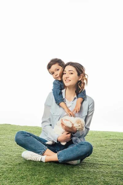 Sorridente madre tenendo Havanese cucciolo e figlio abbracciare il suo isolato su bianco — Foto stock