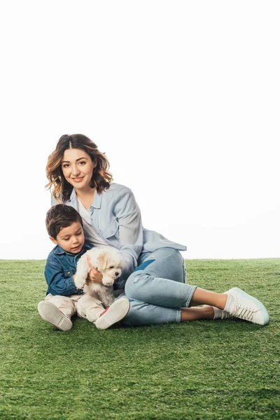 Sorridente madre e figlio con in braccio cucciolo avanese isolato su bianco — Foto stock