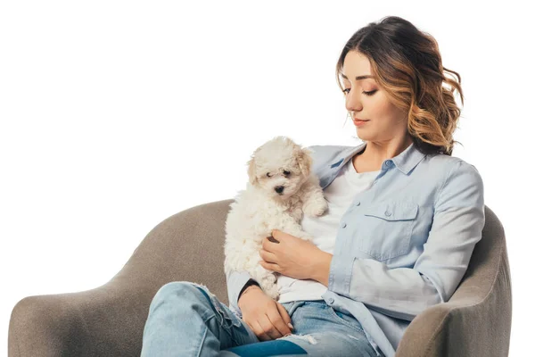 Mujer sosteniendo cachorro Havanese y sentado en sillón aislado en blanco - foto de stock