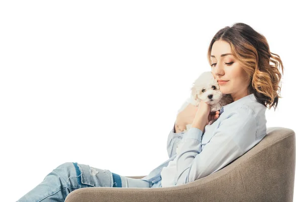 Femme tenant un chiot Havanais et assise sur un fauteuil isolé sur blanc — Photo de stock