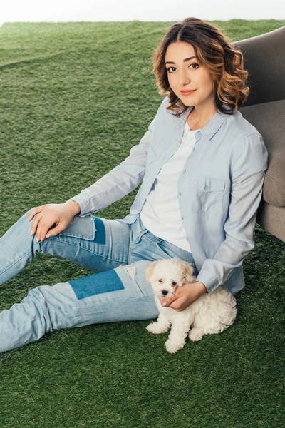 Mujer sonriente con lindo cachorro de Havanese sentado en la hierba - foto de stock