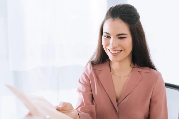 Focus selettivo di consegna uomo dando busta alla donna d'affari sorridente — Foto stock